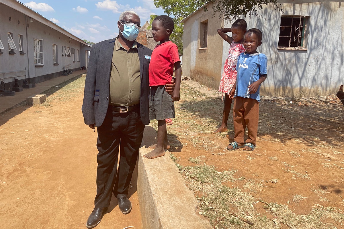 United Kingdom Mission Area Ambassador Jabulani Gumbodete visits with orphans at Home of Hope at Nyadire Mission. The UK Mission Area donated nearly $18,000 to help care for orphans in Zimbabwe. Photo courtesy of Enock Temba.
