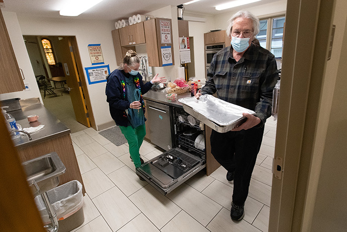 Don Rohde carries a tray of food to store in the basement refrigerator and the Rev. Ruth Marsh exclaims over the way the dishwasher was loaded while they help prepare dinner for shelter guests at Trinity United Methodist Church in Idaho Falls, Idaho. “The tone of the church has changed,” said Rohde, who serves as chair of the board of trustees. “I like to say we’ve become a working church because the focus now is on truly doing the right thing.” Photo by Mike DuBose, UM News. 