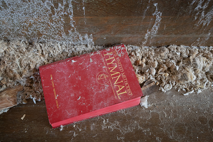A waterlogged hymnal and wet insulation lie on a pew at First United Methodist Church in Mayfield after a tornado collapsed the church’s roof. Photo by Mike Dubose, UM News.
