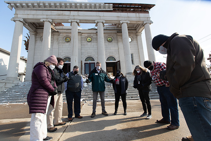 The Rev. Rob Martin (center) leads a prayer for United Methodist church leaders and disaster relief workers during a tornado damage assessment tour outside First United Methodist Church in Mayfield. Photo by Mike Dubose, UM News.