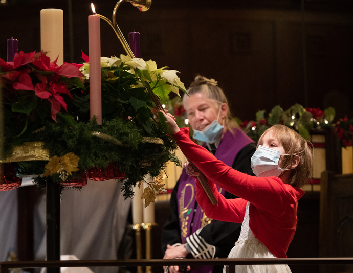 Acolyte Sophia Griffith, 8, lights an advent candle at Trinity United Methodist Church. Behind her is the Rev. Ruth Marsh. Photo by Mike DuBose, UM News.
