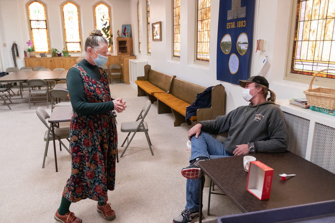 The Rev. Ruth Marsh visits with Dave Carson, a guest of the day shelter. Photo by Mike DuBose, UM News.