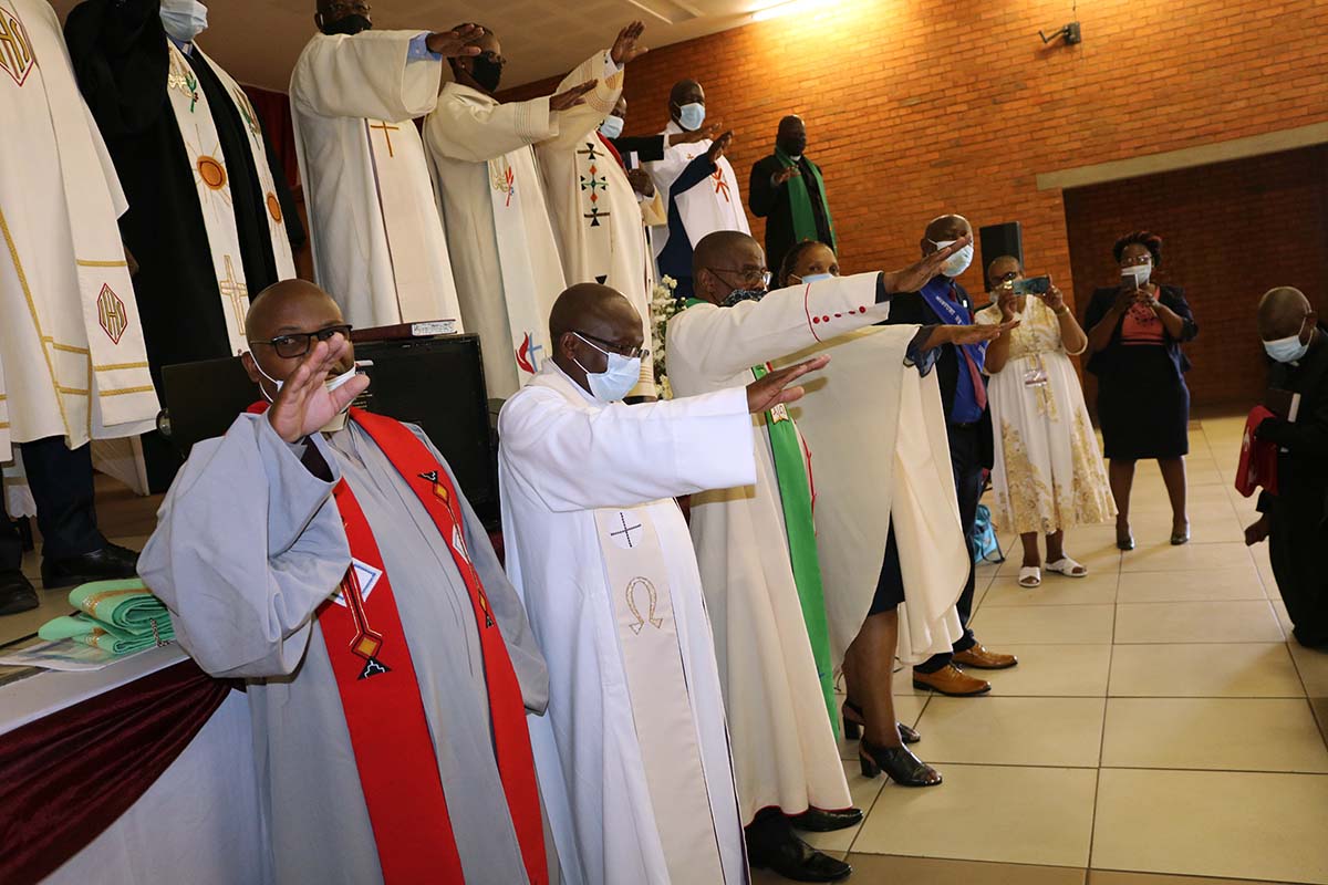 O Rev. Mills Maliwa, Assistente Administrativo da bispa lidera as orações dos clerigos pelos pastores ordenados durante a 18ª sessão da Conferência Anual da África do Sul. Foto de Alvin Makunike, Noticias da MU.