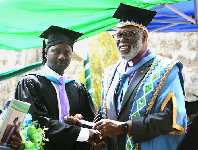 Interim Sierra Leone Conference Bishop Warner H. Brown (right) awards a symbolic certificate in Bachelor of Theology with Honors Degree in Christian Education to the Rev. Stephen N. Senesie. Senesie was among the first students to graduate from The United Methodist University in Sierra Leone, which opened in late 2017. Photo by Phileas Jusu, UM News. 