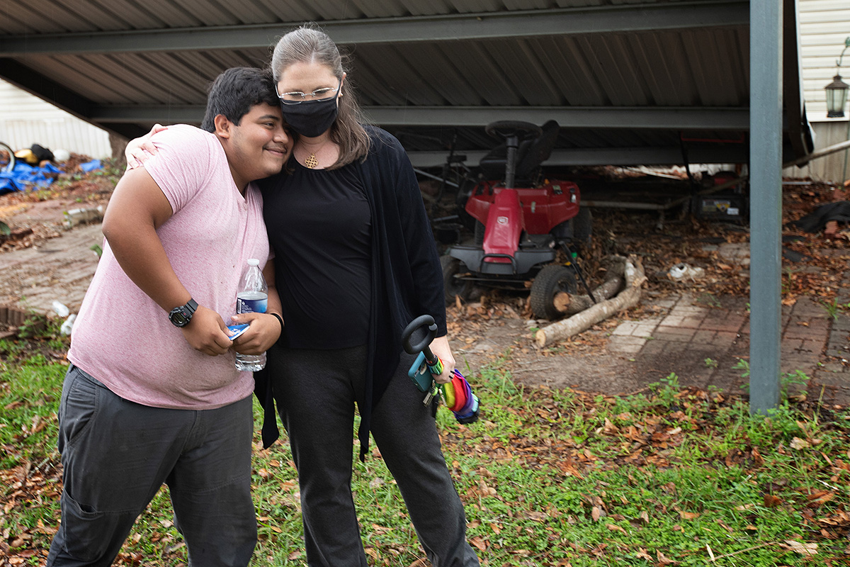 The Rev. Angela Cooley Bulhof hugs Caton Darling during a visit to his home in Lake Charles, La., to check on the progress of repairs following Hurricane Laura in 2020. Bulhof, pastor of University United Methodist Church in Lake Charles, says Louisiana has been pounded by seven hurricanes and two tropical storms since August 2020. File photo by Mike DuBose, UM News.