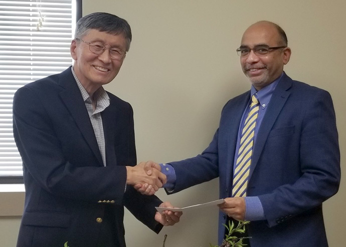 Retired United Methodist Bishop Young Jin Cho (left) presents to Roland Fernandes, top executive of the United Methodist Board of Global Ministries and UMCOR, a $100,000 check from an anonymous member of the Korean (United Methodist) Church of Atlanta. The money is for the denomination’s relief efforts in and around Ukraine. Cho serves as the church’s interim pastor. Photo courtesy of the Korean Church of Atlanta.