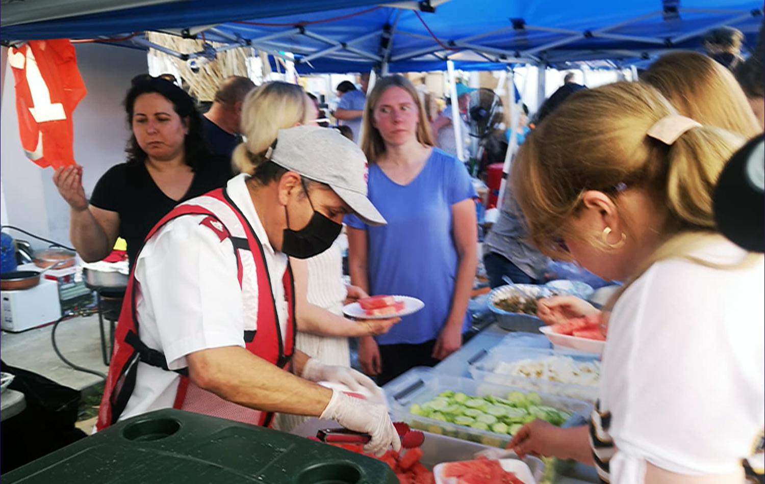 Voluntarios/as de la Iglesia Metodista de México y del Ejército de Salvación, distribuyen alimentos entre las familias ucranianas que se mantienen en un gimnasio que sirve como albergue, mientras esperan las citas para cruzar la frontera a los EE.UU. Foto cortesía del Obispo Felipe Ruiz, Iglesia Metodista de México A.R.