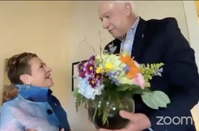 New York Conference Bishop Thomas Bickerton (right), president-designate, surprised current Council of Bishops President Cynthia Fierro Harvey by showing up at her Louisiana office and presenting her with flowers from the council in gratitude for her service as president. During her two-year tenure, the bishops have met more frequently with all meetings done online. Screengrab courtesy of the Council of Bishops via Zoom by UM News.