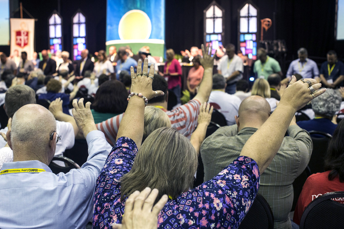 Participantes da Conferência Anual de Kentucky de 2017 em Bowling Green, Kentucky, levantam os braços em oração durante uma "Plenaria com Culto de Adoracao". Em 10 de Maio, o Conselho Judicial divulgou uma decisão que diz que as conferências anuais dos EUA não podem se desfiliar da denominação sob a lei actual da igreja. Foto de arquivo de Kathleen Barry, Noticias da UM.
