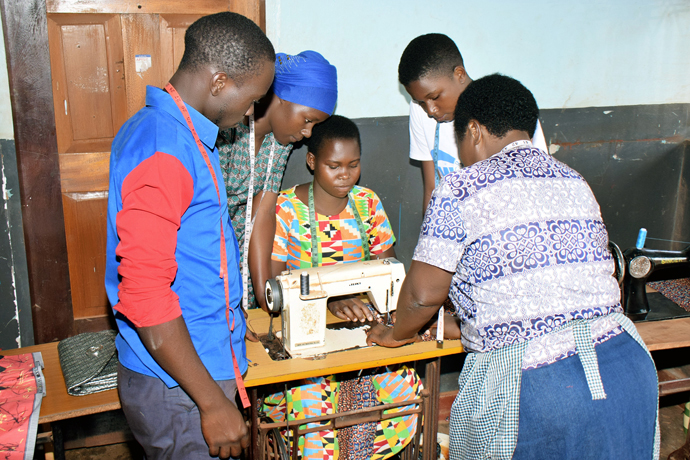 Uma professora conduz as alunas numa aula de costura no Centro de Formação de Mulheres da Igreja Metodista Unida em Bugembe, Uganda. O centro recebeu uma subvenção de US$5.400 para comprar maquinas de costura para formar mulheres locais. Foto de Gad Maiga, Noticias da MU. 