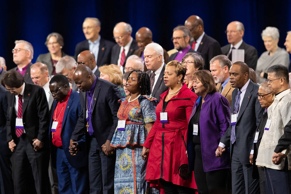 United Methodist bishops hold hands in prayer during a day of prayer for the 2019 United Methodist General Conference in St. Louis. The General Council on Finance and Administration board approved a monthly stipend for active bishops who have led more than one episcopal area since January 2021. File photo by Mike DuBose, UM News.