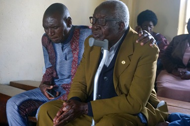 Toendepi Samson Marikasi sobs with grief over the loss of his wife, Alice Marikasi, 87, and her sister, Ellah Muti, 90, during a special memorial service at St. James Hwedza United Methodist Church in Zimbabwe. Pastor Daniel Luckson consoles him. United Methodist churches in Zimbabwe held services where people who lost loved ones during COVID-19 could gather to console one another and celebrate life — things they were unable to do during pandemic restrictions. Photo by Kudzai Chingwe, UM News. Toendepi Samson Marikasi sobs with grief over the loss of his wife, Alice Marikasi, 87, and her sister, Ellah Muti, 90, during a special memorial service at St. James Hwedza United Methodist Church in Zimbabwe. Pastor Daniel Luckson consoles him. United Methodist churches in Zimbabwe held services where people who lost loved ones during COVID-19 could gather to console one another and celebrate life — things they were unable to do during pandemic restrictions. Photo by Kudzai Chingwe, UM News.