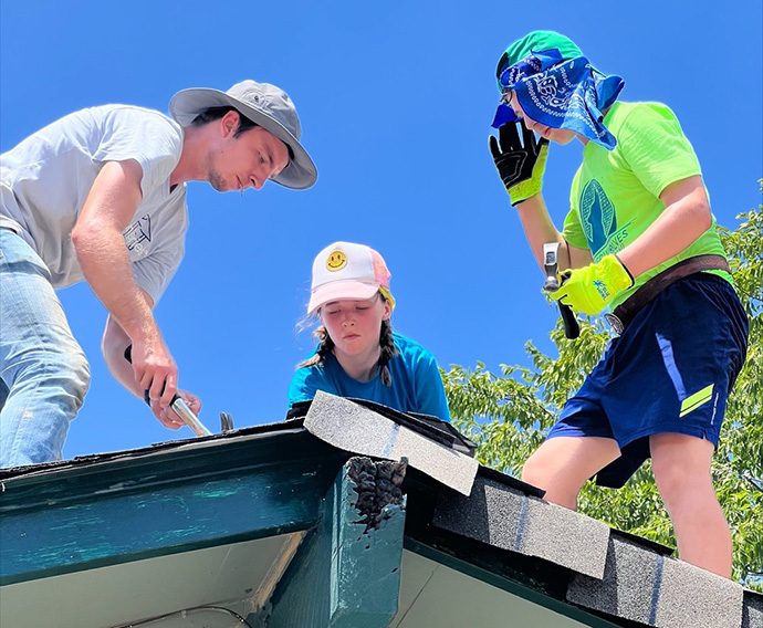 Youth from First United Methodist Church in Dallas help repair a roof in 105-degree heat during their recent summer mission trip to San Antonio. Nick Janzen (left), construction manager for Blueprint Ministries, works with Vivian Winston and Wesley Stoker of the Dallas church. Photo by Anna Bundy-Hagler.  