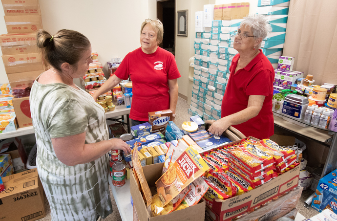 Flood survivor Rosemarie Peak (left) visits with volunteers Rose Calhoun (left) and Debbie Holcomb while picking up relief supplies at United Methodist Mountain Mission. Photo by Mike DuBose, UM News.