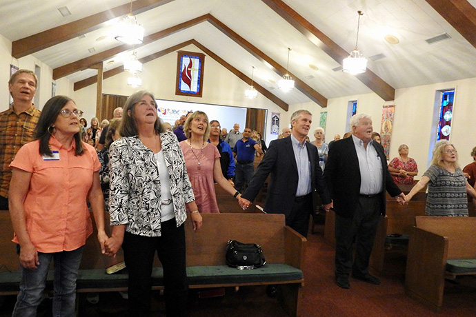 Members and guests of First United Methodist Church of Aransas Pass, Texas, sing during an Aug. 14 service commemorating when the church filled in as its community’s hospital, following Hurricane Celia in 1970. More than 80 babies were born at the church in the four months before Aransas Pass Hospital was back in operation. Three of the Hurricane Celia babies, as well as one mother and a nurse, returned for the reunion. Photo by Sam Hodges, UM News.