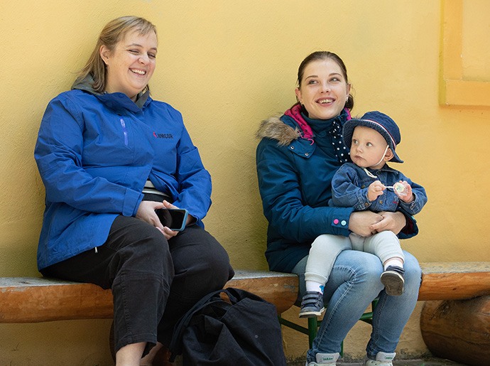 Katie Hills Uzoka (à gauche) de United Methodist Committee on Relief rend visite à Vlada et son fils, Dima, au camp de l’Église Méthodiste Unie de Poušť. La mère et l’enfant ont fui leur maison près de Mykolaiv, en Ukraine, après que son mari soit parti à la guerre dans le cadre du service militaire obligatoire en Ukraine. Uzoka est directrice de la réponse internationale aux catastrophes pour l’agence d’assistance humanitaire de la dénomination. Photo de Mike DuBose, UM News. 