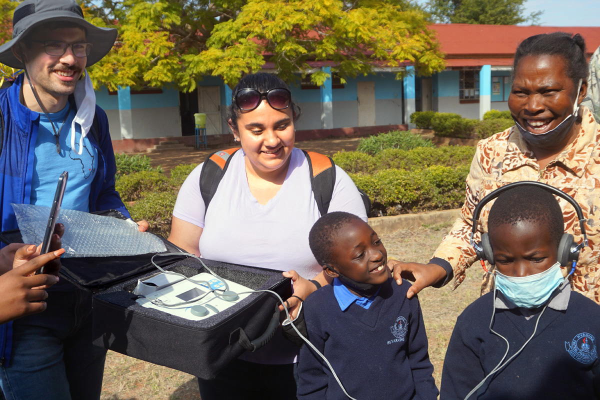 Nyasha (with headset), a second grade student in the hard-of-hearing class at Nyadire Primary in Zimbabwe, tries out an auto-hearing machine machine donated to the school by the Northwest District of the Indiana Conference. Also pictured are David Czerwonky (left) with the Wesley Foundation of Purdue University; Janée LaFuze (center), Northwest District lay leader; Ruvarashe, another student; and teacher Everjoy Nyamukapa (far right). During a July 13-Aug. 4 mission trip, visitors from the Northwest District and the Wesley Foundation of Purdue connected with church members in the Zimbabwe Episcopal Area.