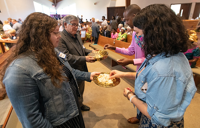 Acacia Zuninga (left) and the Rev. Jorge Ramirez offer Holy Communion during a Festival of Nations celebration of World Communion Sunday at Hillcrest United Methodist Church in Nashville, Tenn. They help lead the Casa de TransformaciÃ³n congregation that worships at Hillcrest. Photo by Mike DuBose, UM News.