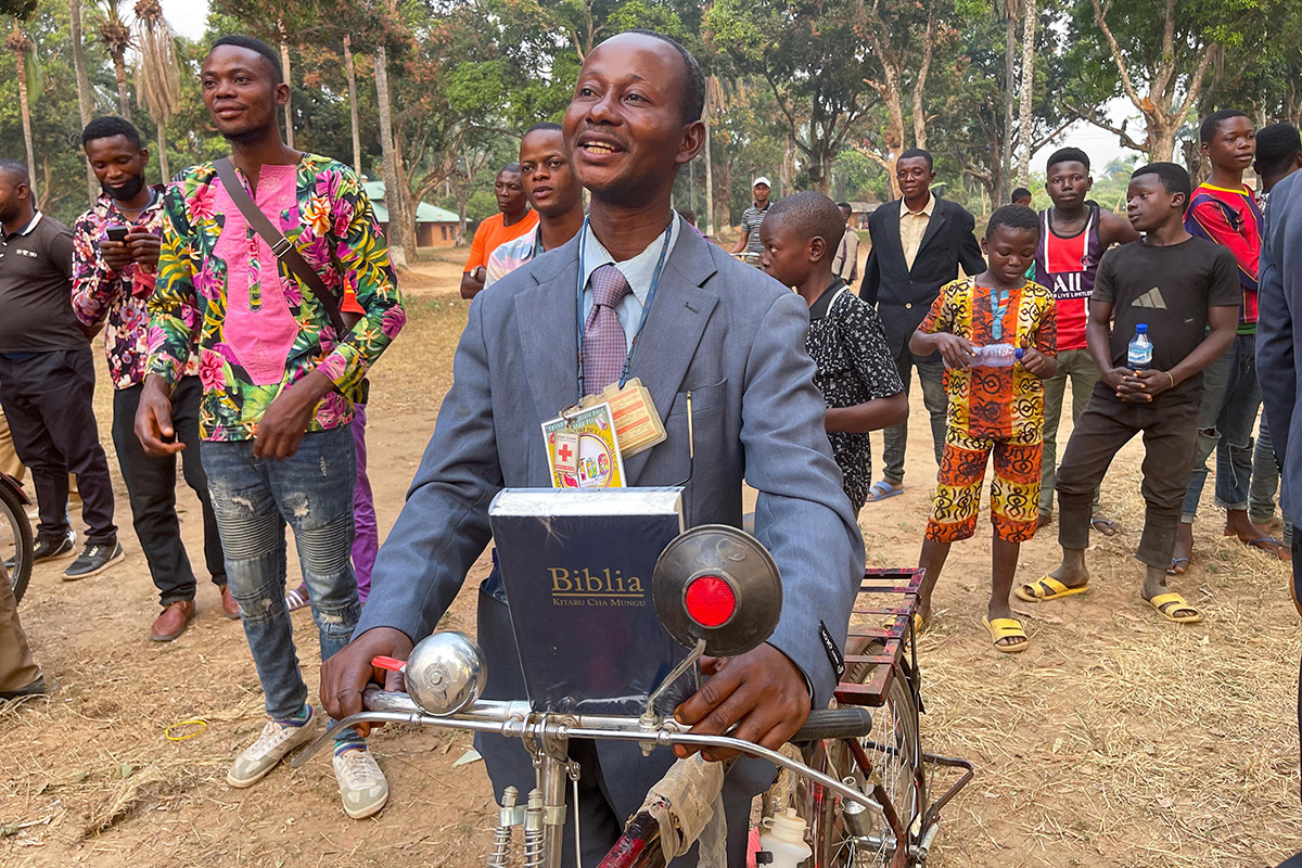 The Rev. Ngongo Asaka smiles after receiving a new bicycle and a Bible as tools for evangelism in Tunda, Congo. Asaka was among 52 pastors of rural United Methodist churches in the area who received the gifts from Crosspoint, a United Methodist church in Niceville, Fla. Photo by Chadrack Londe, UM News. 