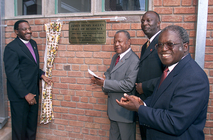 Rukudzo J. Murapa (right) applauds during the dedication service for a new residence hall at Africa University in 2002. He was joined at the dedication service by (from left) now-retired Bishops Woodie W. White (left) and Emilio de Carvalho and James Salley, Africa University associate vice chancellor, for whom the residence hall is named. File photo by Mike DuBose, UM News.