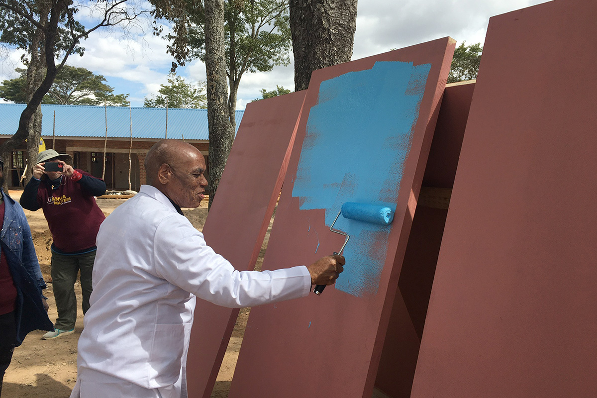Bishop Eben K. Nhiwatiwa paints a door while working with a Volunteers in Mission team in July at the United Methodist Hanwa Mission Primary School in Zimbabwe. Photo by Erik Alsgaard.