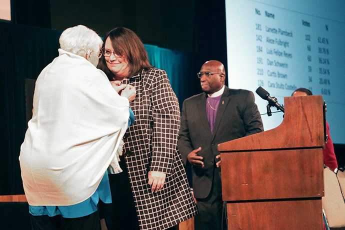 Retired Bishop Sharon Rader gives newly elected Bishop Lanette Plambeck her episcopal pin following her election to the United Methodist episcopacy at the North Central Jurisdictional Conference in Fort Wayne, Ind., on Nov. 2. Photo by Kaitlyn Winders Photography.