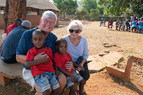 Charles and Carol Moore spend time with Blessed (left) and Blessing, twin boys they sponsor through the Fairfield Outreach and Sponsors Association. The Moores were in Mutare, Zimbabwe, to take part in the presentation of $800,029 donated to the Fairfield Children’s Home by the United Methodist South Carolina Conference. Photo by Kathy L. Gilbert.