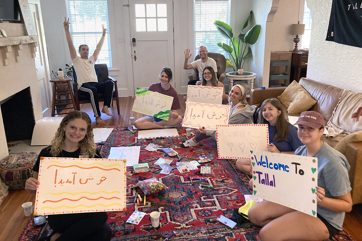 Neighborly’s "Welcome Party" volunteers create signs that say “welcome” in Arabic, Pashto and Dari, to use at airport pickups when refugees from Afghanistan and Syria first arrive to Tallahassee, Florida. James Barnett is seated at right rear. Photo courtesy of Kristin Barnett.