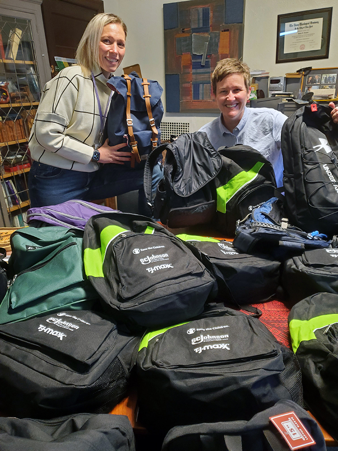 Andrea Steinkamp, left, a St. Paul and St. Andrew intern, and the Rev. Lea Matthews show off some of the many backpacks that have been donated to the church’s migrant ministry work. Photo courtesy of St. Paul and St. Andrew.