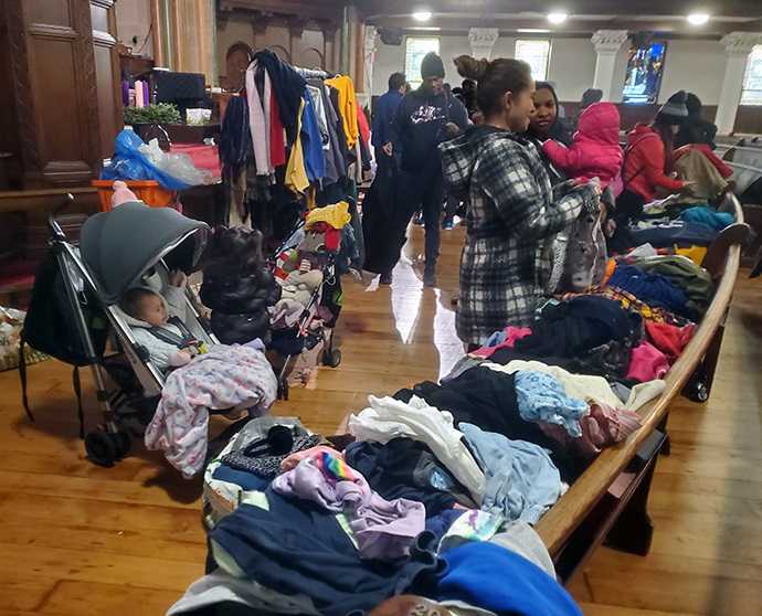 Donated clothing fills a front pew at the Church of St. Paul and St. Andrew in New York City, including coats and warmer garments for the approaching winter. Photo by K Karpen.