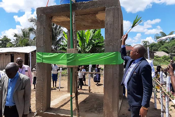 Lors de la cérémonie inaugurale, l’Évêque Daniel Lunge entrain de bénir le forage d'eau potable construit au centre-ville de Lodja à côté de l'Église Méthodiste Unie Locale Lokenye.  Pour lutter contre les maladies d’origines hydriques fréquentes dans la région, l’Église Méthodiste Unie a réalisé dix-huit forages d’eau potable dans la Conférence Annuelle du Congo Central. Photo par François Omanyondo, UM News.