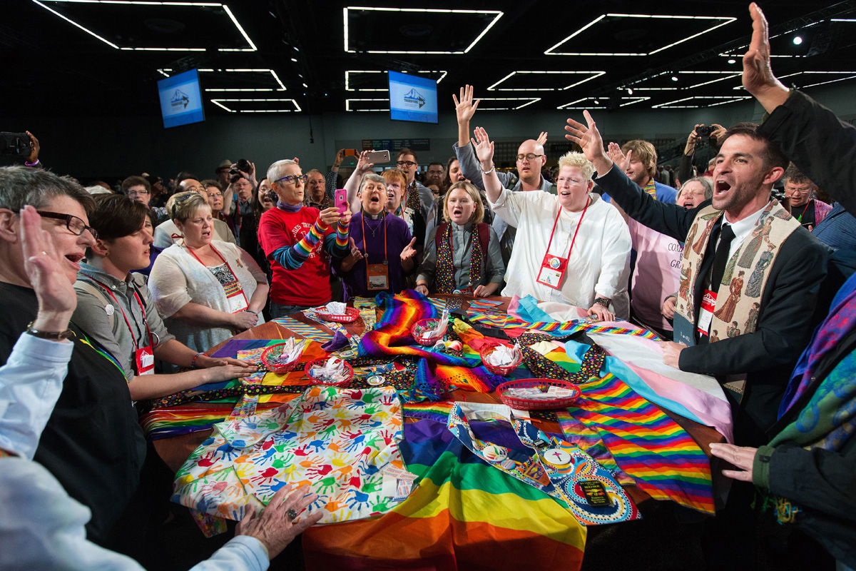 Supporters of LGBTQ rights in The United Methodist Church rally around the central Communion table at the close of the 2016 United Methodist General Conference in Portland, Ore. An updated edition of “American Methodism,” a history of the denomination published by Abingdon Press, adds a chapter covering 20 years of contentious debate over sexuality. File photo by Mike DuBose, UM News.