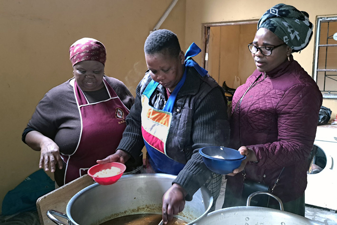 (From left) Nokwanda Keleku looks on as Nosicelo Dubula of St. Joseph United Methodist Church and Nomzi Dali, president of the Cape Coastal District’s women’s organization, prepare to serve food at Masakhane Soup Kitchen in Cape Town, South Africa. Keleku founded the soup kitchen with fellow United Methodist Vuyelwa Thanda in 2020 during the COVID-19 pandemic. Photo by Alvin Makunike, UM News.
