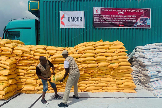 Jean Tshomba and Cudins Lokale, members of The United Methodist Church’s disaster management office in East Congo, lift bags containing rice and cornmeal during relief distribution in Goma in January 2023. Funding from the United Methodist Committee on Relief purchased more than 165 tons of food and non-food items distributed to more than 2,500 households or approximately 12,500 people. Photo by Chadrack Tambwe Londe, UM News.