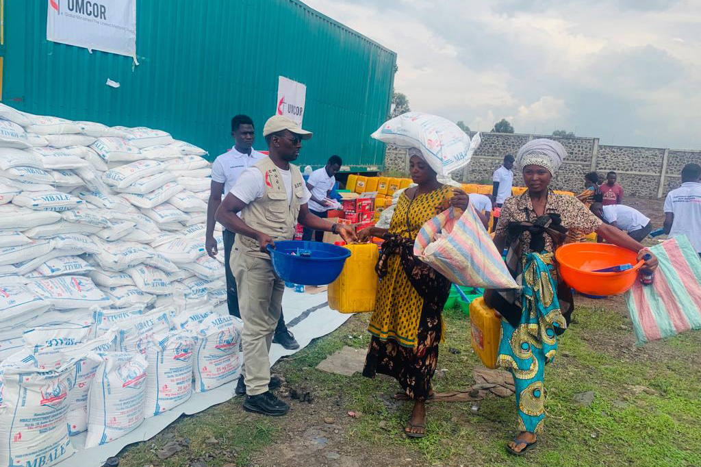 Jean Tshomba, coordinator of UMCOR's disaster management office in East Congo, delivers food and other relief items to a woman displaced by war. According to data provided by the United Nations Office for the Coordination of Humanitarian Affairs, more than 521,000 people, mainly women and children, are living with host families or in sites for displaced persons in the region. Photo by Chadrack Tambwe Londe, UM News.