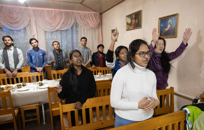 Parishioners sing during a service at Bishkek United Methodist Church. The table is set for a fellowship meal in the sanctuary following worship. Photo by Mike DuBose, UM News.