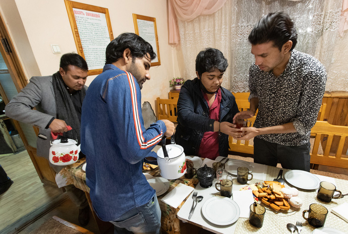 Students from Pakistan pour tea for a fellowship meal in the sanctuary at Bishkek United Methodist Church. From left are Muslam Hanif, Thomson Gill, Prince Javaid and Sanwal Shabir.. Photo by Mike DuBose, UM News.