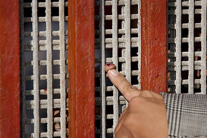 A wire mesh fence barely allows fingertip contact across the U.S.-Mexico border in the Tijuana area. Photo by Mike DuBose, UM News.