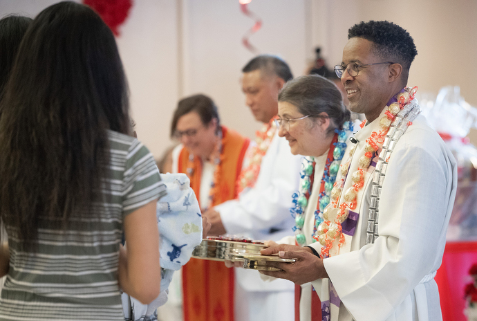 Members of the clergy serve Holy Communion during the chartering service. From right are Bishop Cedrick Bridgeforth and the Revs. Christina DowlingSoka, Fa’atafa Fulummu’a and Lisa Talbott. Photo by Mike DuBose, UM News.