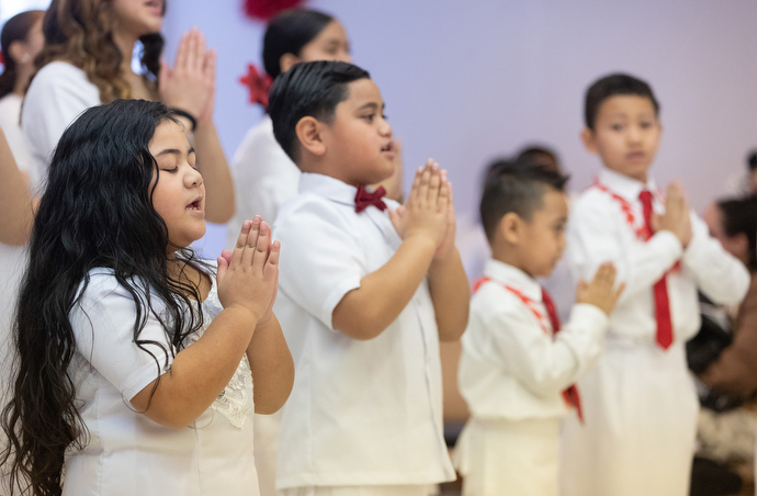 Children pray during the chartering service. Photo by Mike DuBose, UM News.