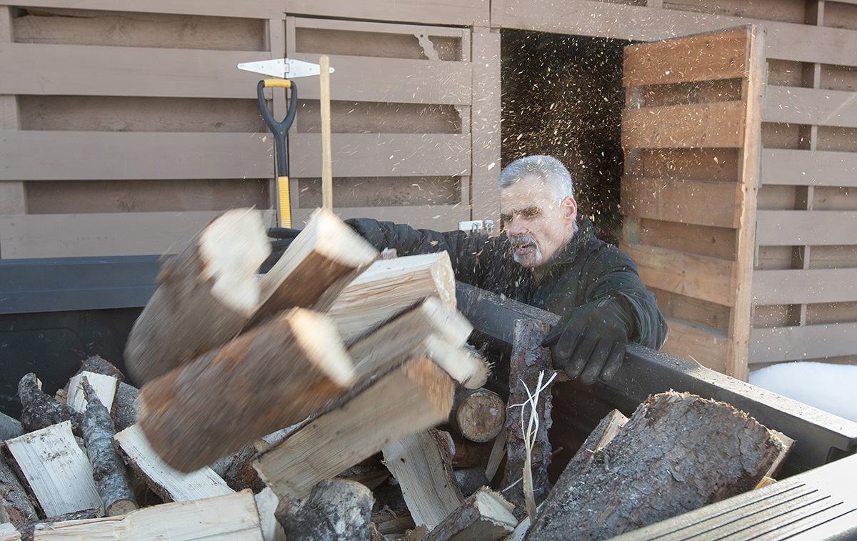 Jimmie Hutson loads firewood that he will use to help heat his home from a woodshed at the Willow (Alaska) Community Food Pantry. Hutson is both a regular volunteer at the pantry and occasionally receives aid from the program. Photo by Mike DuBose, UM News.