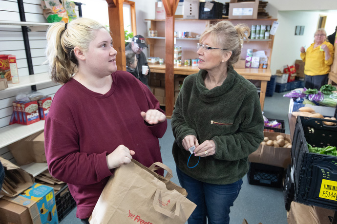 Lilyahna Bohlare (left) visits with volunteer Berna Brooks while selecting groceries at the Willow (Alaska) Community Food Pantry. Photo by Mike DuBose, UM News.