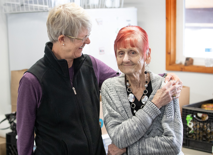 Volunteer Lisa Darnell (left) hugs fellow volunteer Judy Hannaman at the Willow Community Food Pantry, a ministry of Willow United Methodist Church in Willow, Alaska. Hannaman said the camaraderie among volunteers is her favorite part of the ministry. Photo by Mike DuBose, UM News.