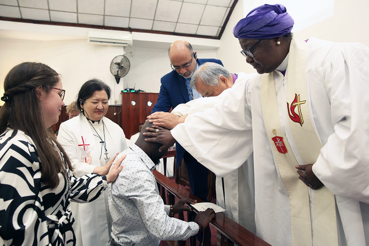 Global Mission Fellow Steven Chingadza (center) receives blessings during an April 20 commissioning service at Malanga United Methodist Church in Maputo, Mozambique. Laying hands on Chingadza are (clockwise from left) Hannah Hanson, director of young adult mission service at Global Ministries; the Rev. Judy Chung, executive director of missionary service at Global Ministries; Global Ministries top executive Roland Fernandes; Bishop Hee-Soo Jung and Bishop Joaquina Nhanala. Photo by Roque Facela.