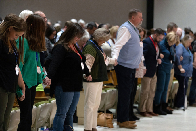 Members of the North Carolina Conference of The United Methodist Church pray during a Nov. 19 special session for approving local church disaffiliations. Ethical questions have arisen as The United Methodist Church deals with churches wanting to depart with their property, and the Rev. Dr. David P. Gushee, a Baptist and author of many works on Christian ethics, has advice for how those questions might be addressed. File photo by Amanda Packer, courtesy of the North Carolina Conference.
