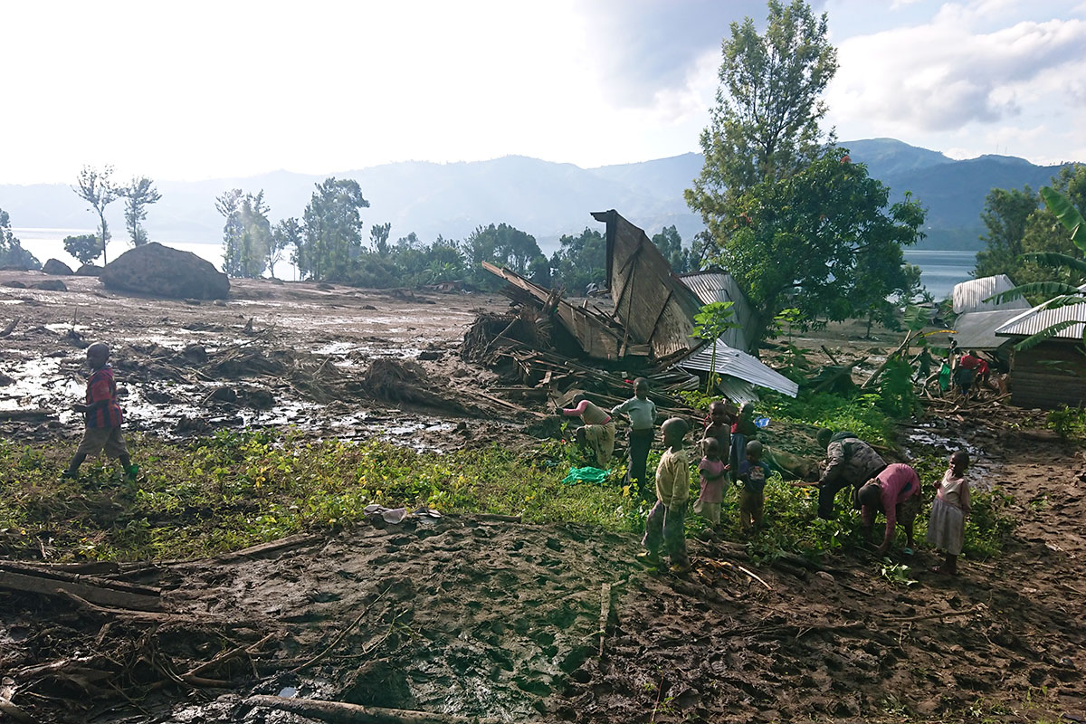 Niños/as caminan entre escombros causados por las inundaciones masivas en la aldea de Bushushu en Kalehe, Congo. Más de 175 personas, incluidos/as 15 metodistas unidos/as, murieron después de que las lluvias torrenciales desbordaran el río Chibira en Kivu del Sur. Foto de Philippe Kituka Lolonga, Noticias MU.