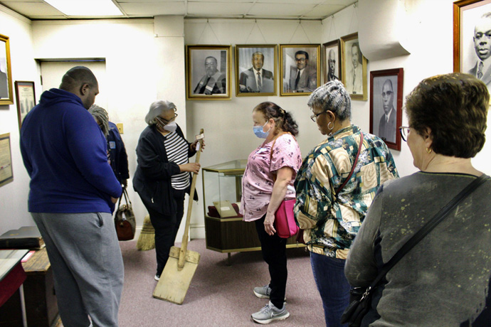 A member of Sharp Street Memorial United Methodist shows an old shovel to pilgrimage visitors at the west Baltimore church. Sharp Street is a descendant of Baltimore’s first African American congregation, which traces its history back to 1787. Photo by Vernon Jordan, UM News.