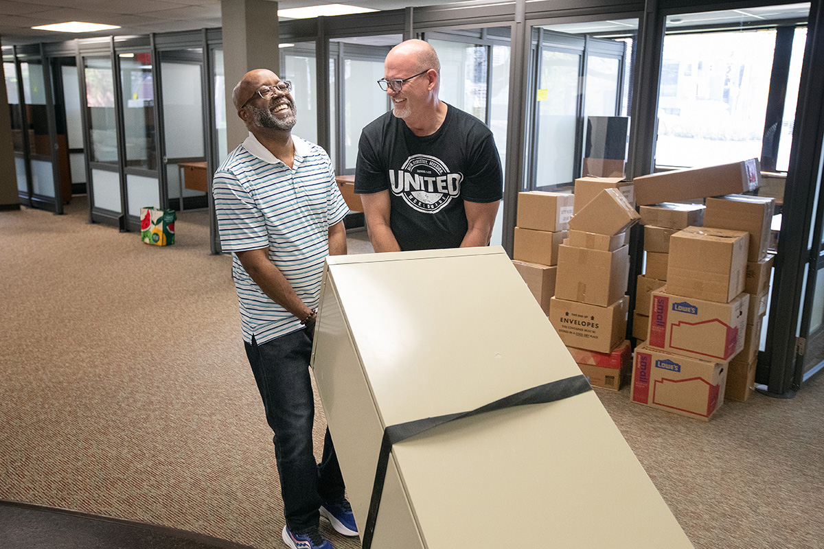 The Rev. Sterling Eaton (left) and Greg Arnold share a laugh as they haul a heavy filing cabinet into their new office at the 810 Twelfth Avenue South building in Nashville, Tenn. Eaton is director of the Center for Men’s Ministries and Arnold is chief executive at United Methodist Men. Photo by Mike DuBose, UM News.