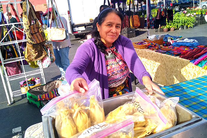 Maria Chavalan Sut makes and sells tamales at the Charlottesville (Va.) City Market. Securing a work permit was one of her goals after spending three years in sanctuary at Wesley Memorial United Methodist Church. Chavalan Sut, an indigenous Guatemalan, is awaiting a ruling in her asylum case. Photo © Richard Lord.