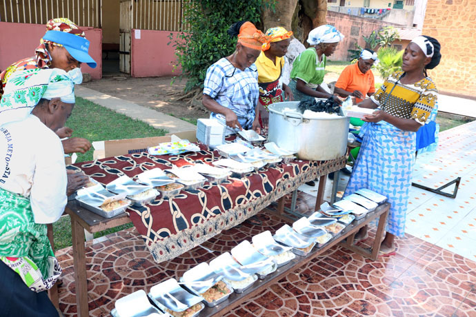 Mães arrumam a comida nas tigela esperando a chegada dos necessitados para distribui-los em Malanje, Angola. Foto de João Gonçalves Nhanga.